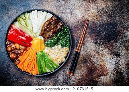 Bibimbap traditional Korean dish rice with vegetables and beef. Top view overhead flat lay copy space