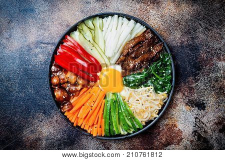 Bibimbap traditional Korean dish rice with vegetables and beef. Top view overhead flat lay