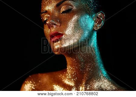 Portrait of Beautiful Woman with Sparkles on her Face. Girl with Art Make-Up in Color Light. Fashion Model with Colorful Makeup