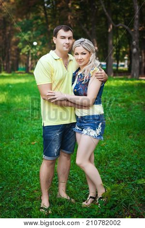 happy healthy couple resting in city park, young family strolls through amusement park