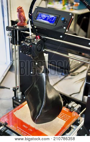 3D printer printing a model in the form of black vase close-up. The concept modern additive technology. The 4ht industrial revolution.