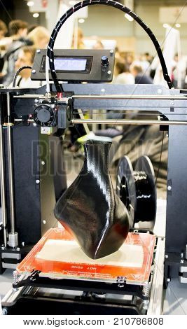 3D printer printing a model in the form of black vase close-up. The concept modern additive technology. The 4ht industrial revolution.