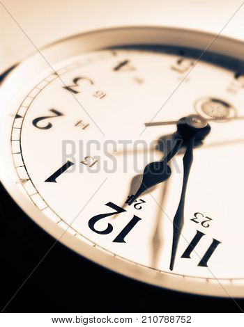CLOSE UP OF CLOCK FACE WITH HANDS POINTING TOWARDS TWELVE O'CLOCK