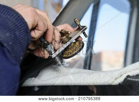 Repair cracked windshield. Fitter is using Windshield Repair Crack Bridge.