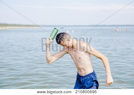 use of alcohol in water bodies. The guy drinks beer in the lake. Abuse of alcohol. drinking alcohol on the water