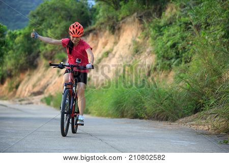 one woman cyclist cycling on mountain trail