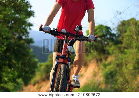 one woman cyclist cycling on mountain trail
