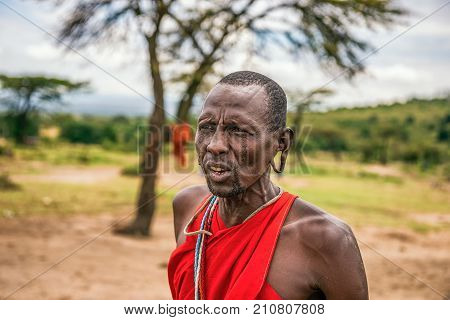 MAASAI MARA, KENYA - OCTOBER 17, 2014 : Portrait of an african men posing in his Masai tribe village. The Maasai are a Nilotic ethnic group living in southern Kenya and northern Tanzania