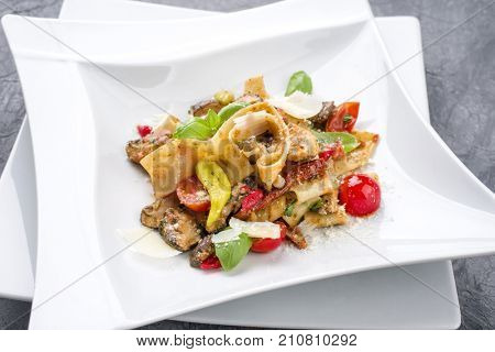 Traditional Italian pappardelle alla cozze with mushrooms and parmesan as close-up on a plate
