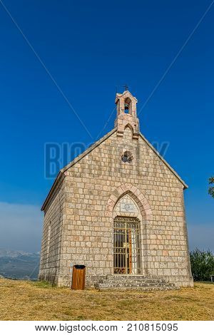 Little stone church on hill above town Sinj was built in 1887, Croatia Europe.
