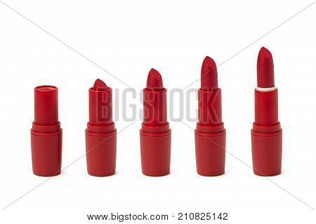 Beautiful red matte lipstick is twisted in a few steps on a white background