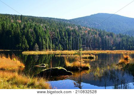 Moraine lake Kleiner Arbersee with mount Gross Arber in National park Bavarian forest. Autumn landscape in Germany.