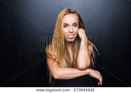 Sexy And Beautiful Young Blonde Model With Slim Body Is Posing In The Studio On The Chair, Dark Wall