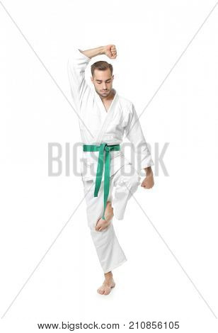 Young man practicing karate on white background