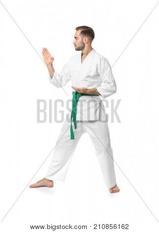 Young man practicing karate on white background
