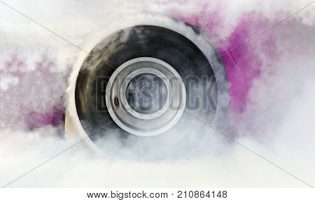 Drag racing car burns rubber off its tires in preparation for the race