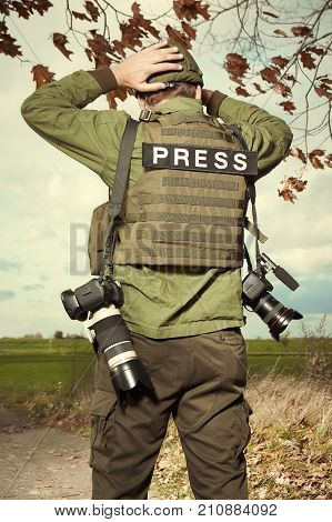 Photographer in war conflict field zone before battle