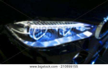 Headlight of a modern sport car. Front view of luxury sport car. Car exterior details. The front lights of the car. Soft lightning