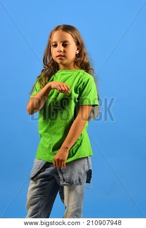 Girl With Serious Face On Blue Background. Childhood And Style