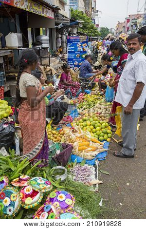PONDICHERY PUDUCHERY INDIA - SEPTEMBER 09 2017. Unidentified man woman at his fruit and or vegetables shop in the main market of the city in south of India Asia.