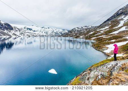 Tourism holidays and travel. Woman tourist standing near Djupvatnet lake relaxing meditation with serene mountains view Stranda More og Romsdal Norway Scandinavia.