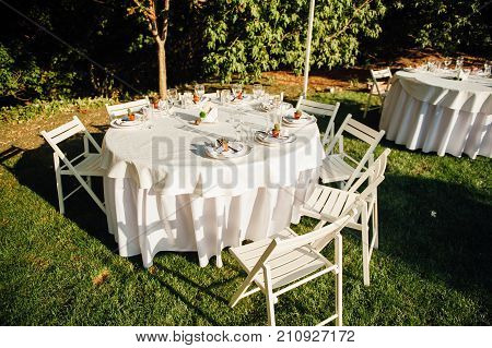 Round banquet table served to the wedding guests arrive. Solar flare on the tablecloth