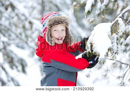 happy smiling boy in beautiful trapper hat at winter enjoying cold weather vacation