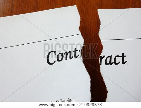 A legal contract ripped in two pieces on a desk