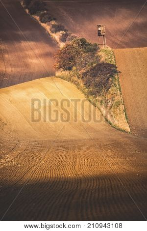 Panoramic vertical view Of beautiful wavy fields with hunting tower in autumn. Agricultural landscape concept with lonely tower in South Moravia near Kyjov town Czech Republic.