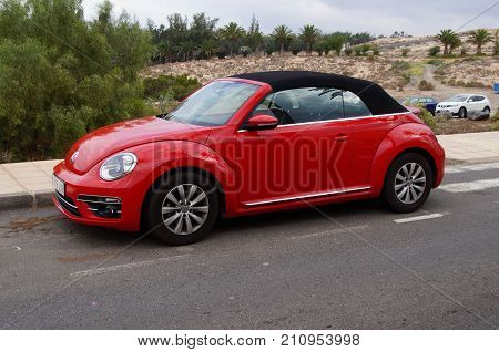Costa Calma, Fuerteventura, Canary Islands, Spain - October 22, 2017: Red Volkswagen Beetle  cabrio parked by the side of the road in the city of Costa Calma. Nobody in de vehicle.