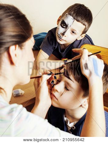 little cute child making facepaint on birthday party, zombie Apocalypse facepainting, halloween preparing concept, lifestyle people close up
