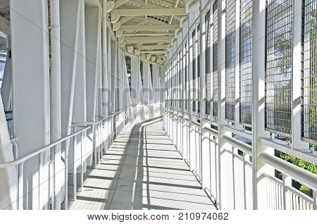Metal footbridge metallic walkway and corridor steel bridge perspective and vanishing point grey atmosphere with nobody
