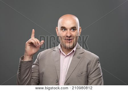 Bald guy having a good idea. Expressive portrait of caucasian bald man on the dark background. Studio shoot.