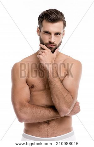 Hmmm are you sure? Portrait of handsome shirtless young man looking at camera while standing against white background.