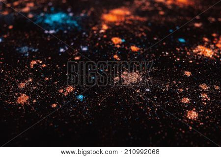 Colorful powdery splashes close up, selective focus. Professional abstract pigment cosmetics background and colourants for creative make up