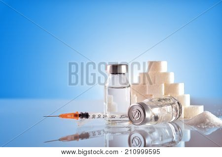 Insulin Vials And Syringe On Table With Blue Background