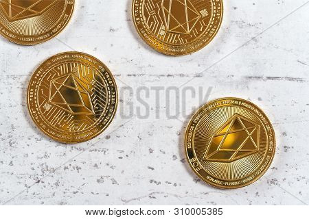 Top Down View, Golden Commemorative Eos - Eosio Cryptocurrency - Coins On White Stone Board