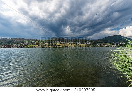 Serraia Lake (lago Della Serraia) With The Italian Alps And The Small Town Of Baselga Di Pine, Trent