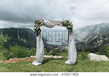 Beautiful Wedding Arch With Flowers On The Background Of The Boko-kotor Bay In Montenegro. Preparati