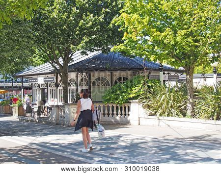 Southport, Merseyside, United Kingdom - 28 June 2019: A Woman Walking Past The Outdoor Cafes In Lord