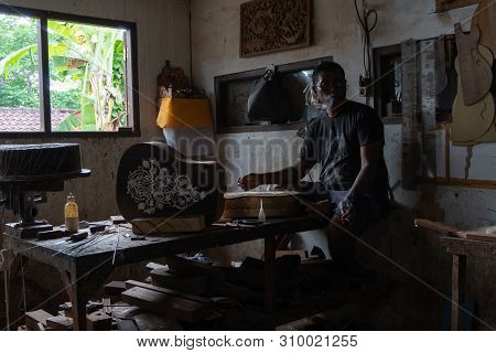 Gianyar,bali/indonesia-may 30 2019: A Guitar Craftsman Creating A Sketch On The Guitar Body At The G
