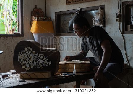 Gianyar,bali/indonesia-may 30 2019: A Guitar Craftsman Creating A Sketch On The Guitar Body At The G