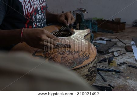 Gianyar,bali/indonesia-may 30 2019: A Classical Guitar Craftsman Is Pairing Guitar Strings To His Gu