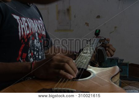 Gianyar,bali/indonesia-may 30 2019: A Classical Guitar Craftsman Is Pairing Guitar Strings To His Gu