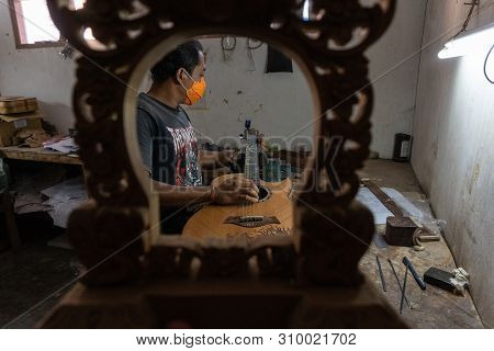 Gianyar,bali/indonesia-may 30 2019: A Classical Guitar Craftsman Is Pairing Guitar Strings To His Gu