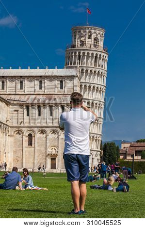 Pisa, Italy - April, 2018: Young Male Tourist Taking Pictures Of The Famous Leaning Tower Of Pisa