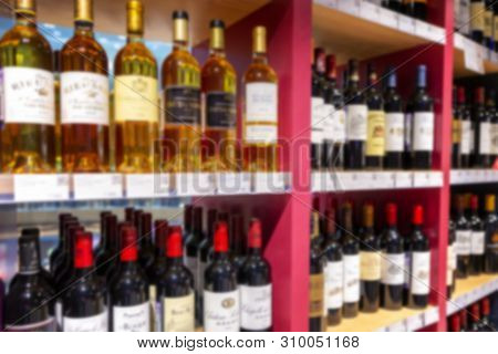 Large Wine Racks. Many Different Alcoholic Beverages. Luxury Enoteca. The Photo Is Blurry. Close-up.
