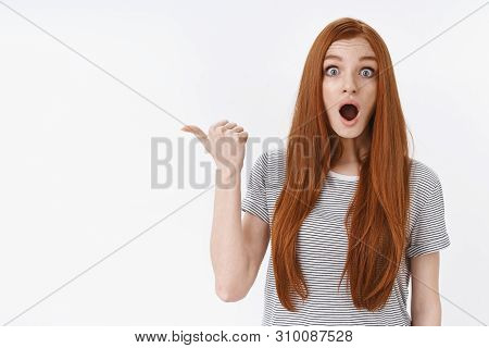 Shocked Impressed Wondered Young Ginger Girl Blue Eyes Staring Stunned Pointing Thumb Left Speechles