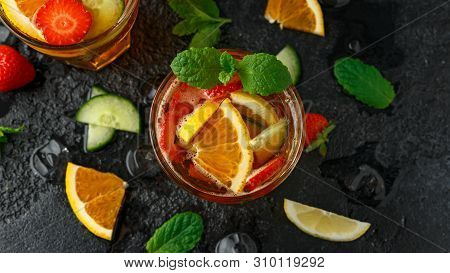 Refreshing Pimms Cocktail With Fruit And Vegetables On Rustic Black Table