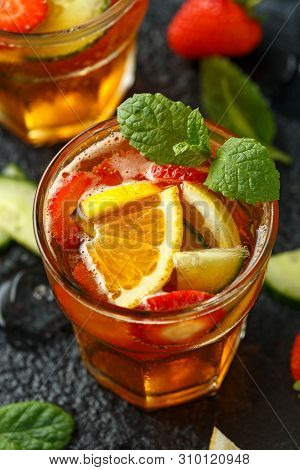 Refreshing Pimms Cocktail With Fruit And Vegetables On Rustic Black Table